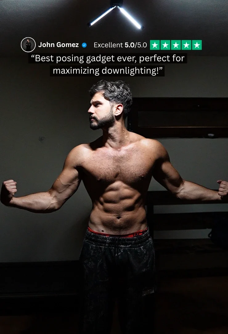 Same athlete lit by a single directional IRONLUME lamp, muscle definition carved by shadow